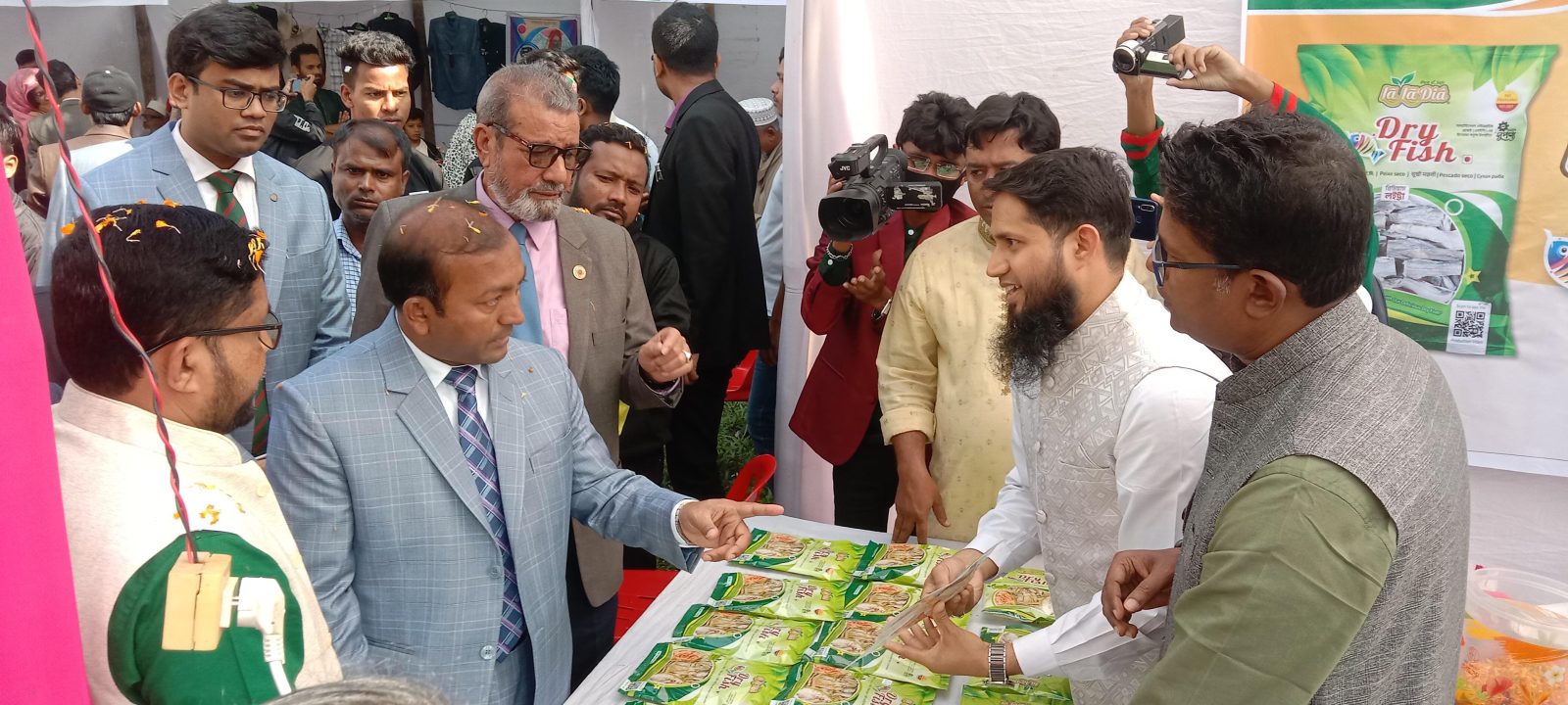 প্রদর্শনীর স্টলে অতিথি ও সাংবাদিকেরা লা লা দিয়ার শুঁটকি মাছের প্যাকেট দেখছেন